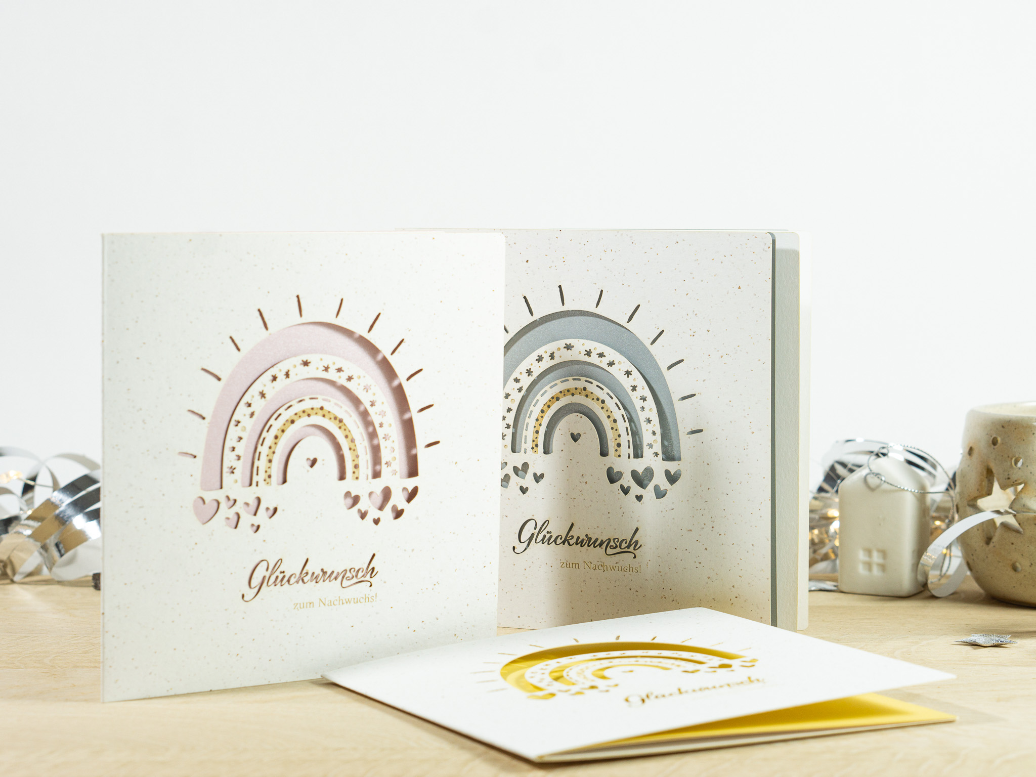 PALUXA_Babyglueck_mit_Regenbogen_3_Varianten_hover.jpg Drei Farbvarianten PALUXA Lasercut-Babykarte mit Regenbogen-Motiv, stehend.