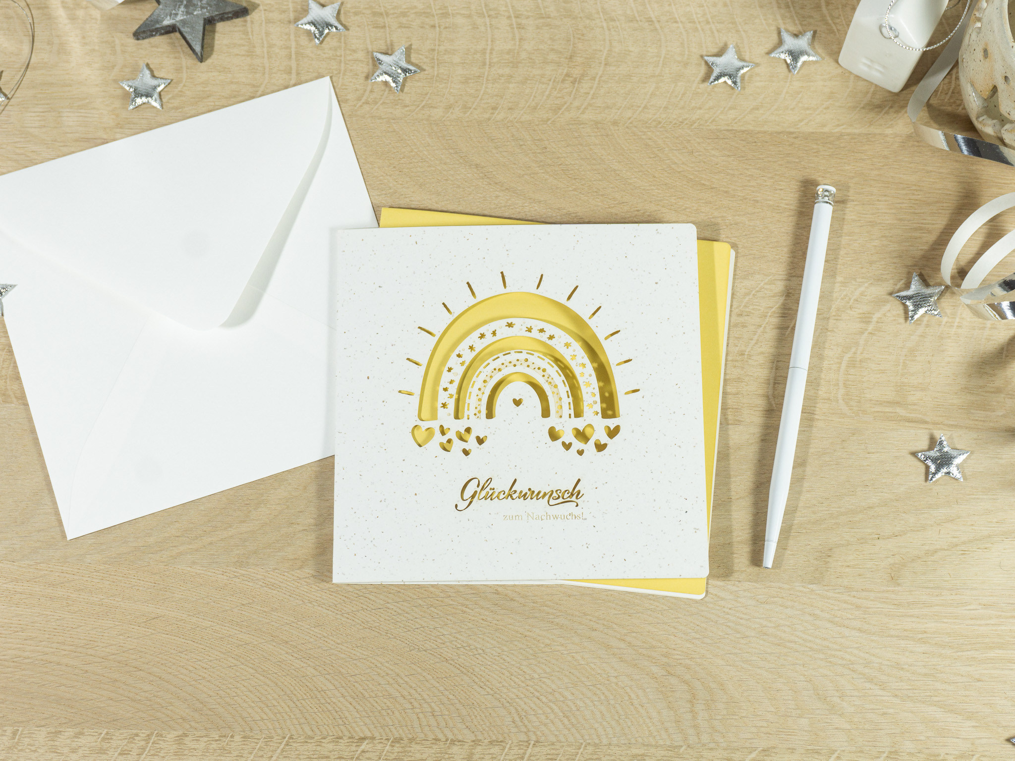 PALUXA_Babyglueck_mit_Regenbogen_Sonnengelb_birdview.jpg PALUXA Lasercut-Babykarte mit Regenbogen-Motiv, gelbes Einlageblatt, seitlich.