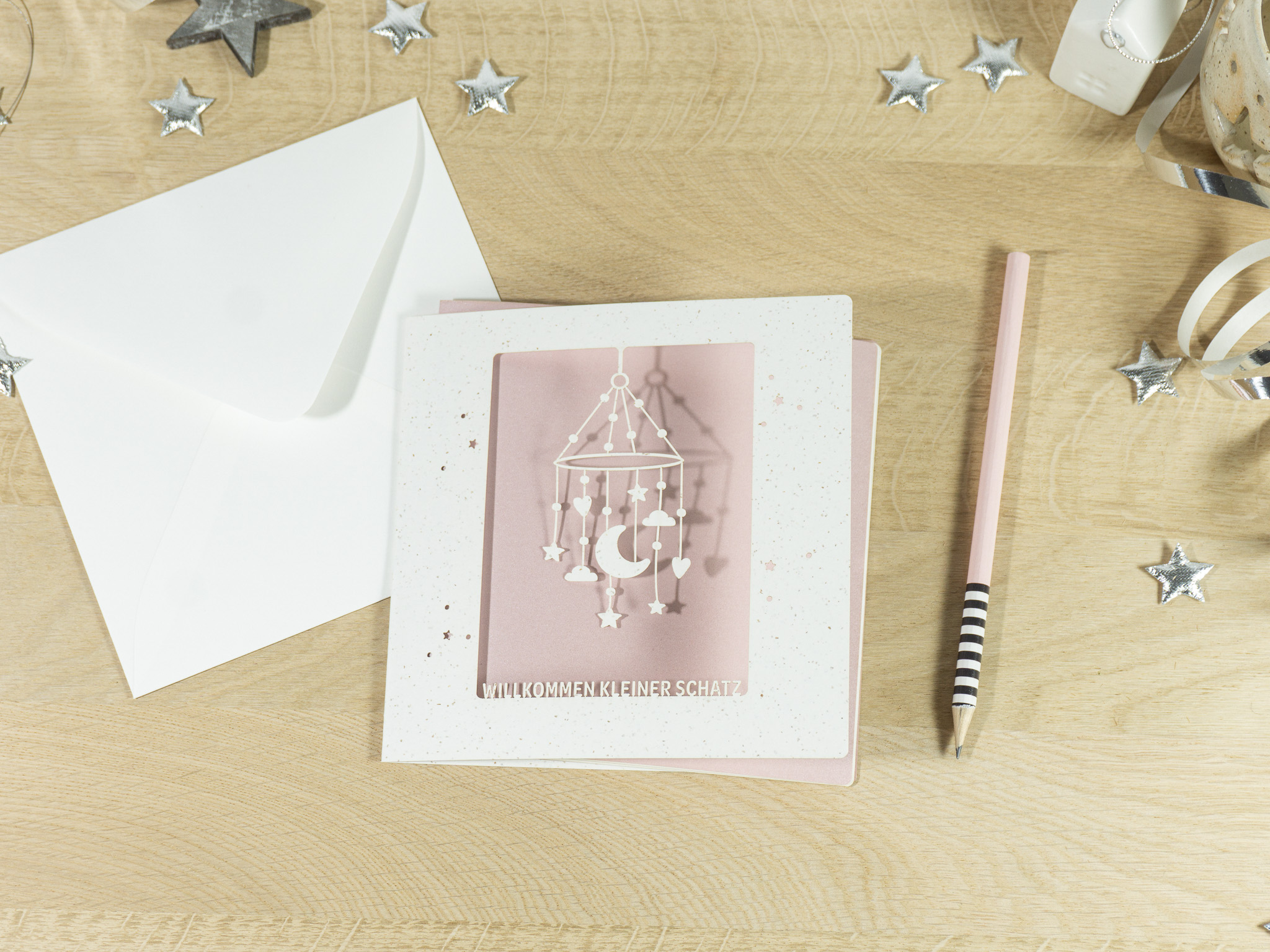 PALUXA_Mobile_MistyRose_birdview.jpg PALUXA Lasercut-Babykarte mit Mobile-Motiv, rosa Einlageblatt, liegend.