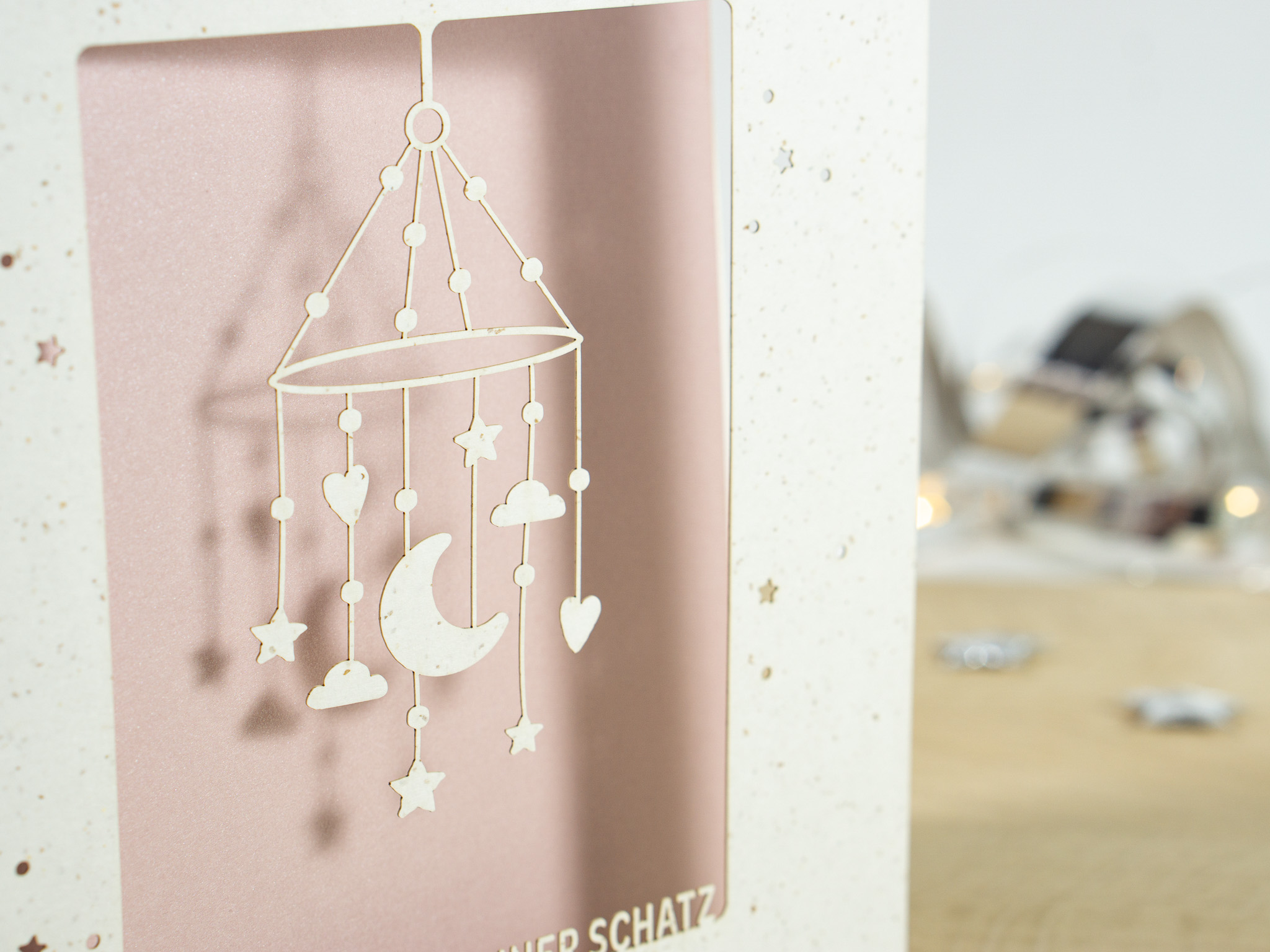 Zoom-In PALUXA Lasercut-Babykarte mit Mobile-Motiv, rosa Einlageblatt, stehend.