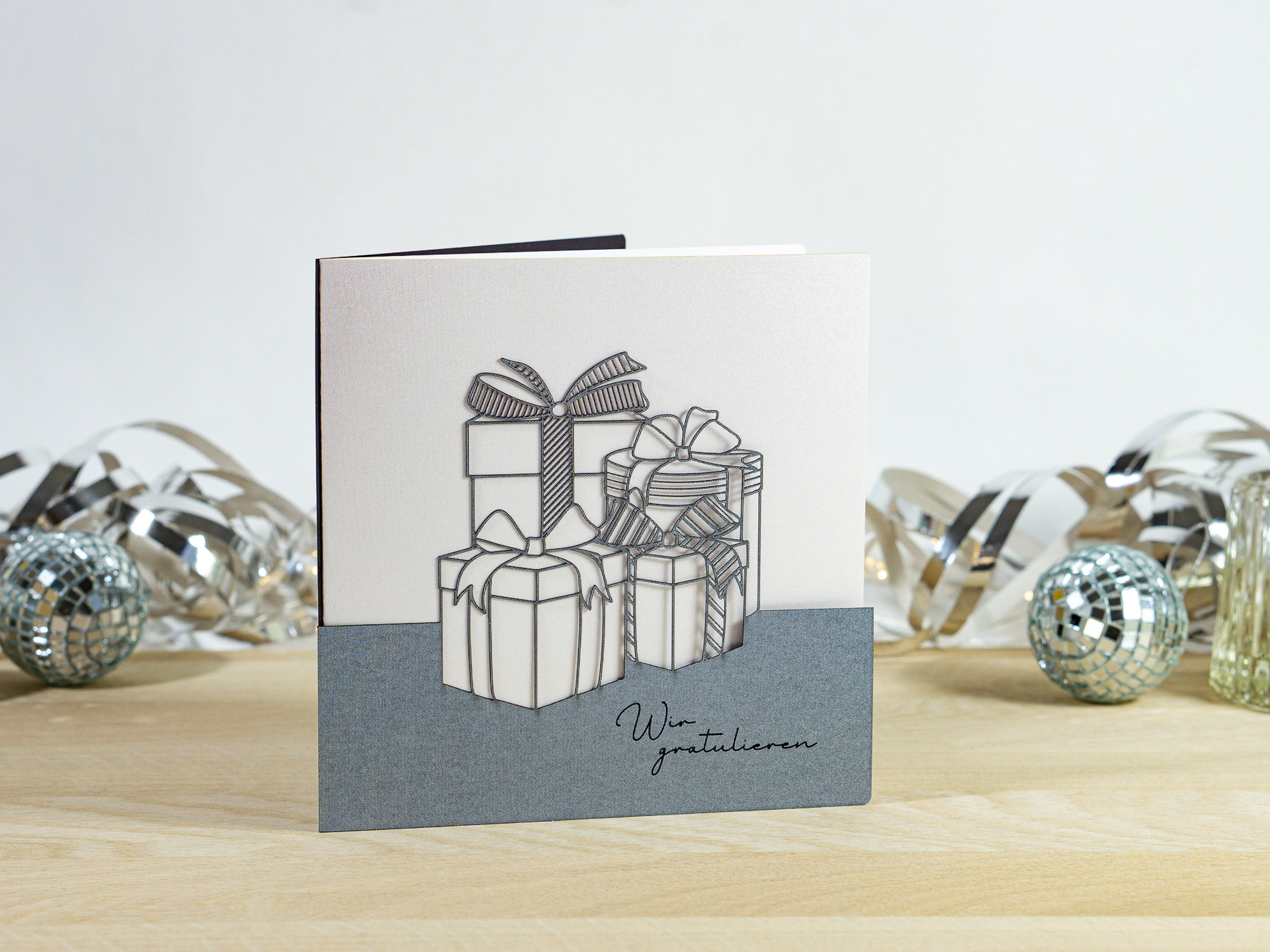PALUXA_Geschenke_Zinnblau_stehend.jpg PALUXA Lasercut-Glückwunschkarte mit Geschenk Motiv, silbernes Außenblatt, stehend.