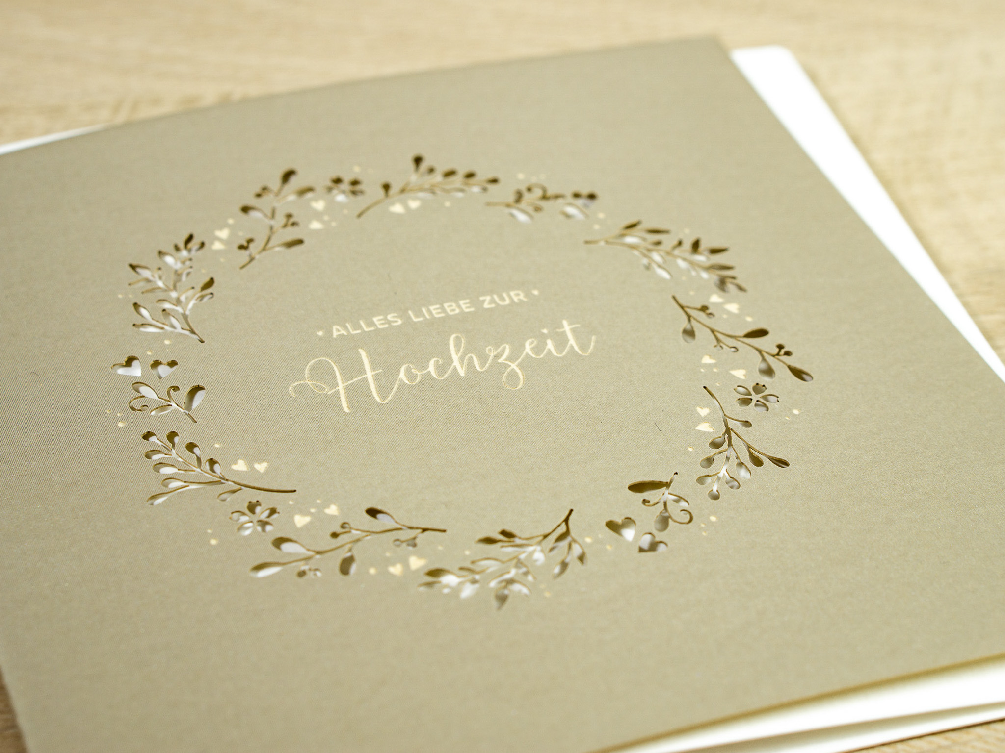Zoom-In PALUXA Lasercut-Hochzeitskarte Gravur mit Kranz, golden, liegend.