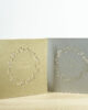 PALUXA_Herzlicher_Kranz_zur_Hochzeit_Varianten.jpg Zwei Farbvarianten PALUXA Lasercut-Hochzeitskarte Gravur mit Kranz, golden und silber, stehend.