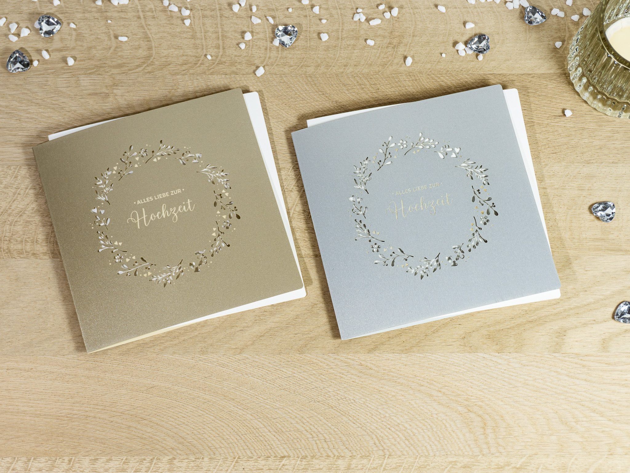 Zwei Farbvarianten PALUXA Lasercut-Hochzeitskarte Gravur mit Kranz, golden und silber, liegend.