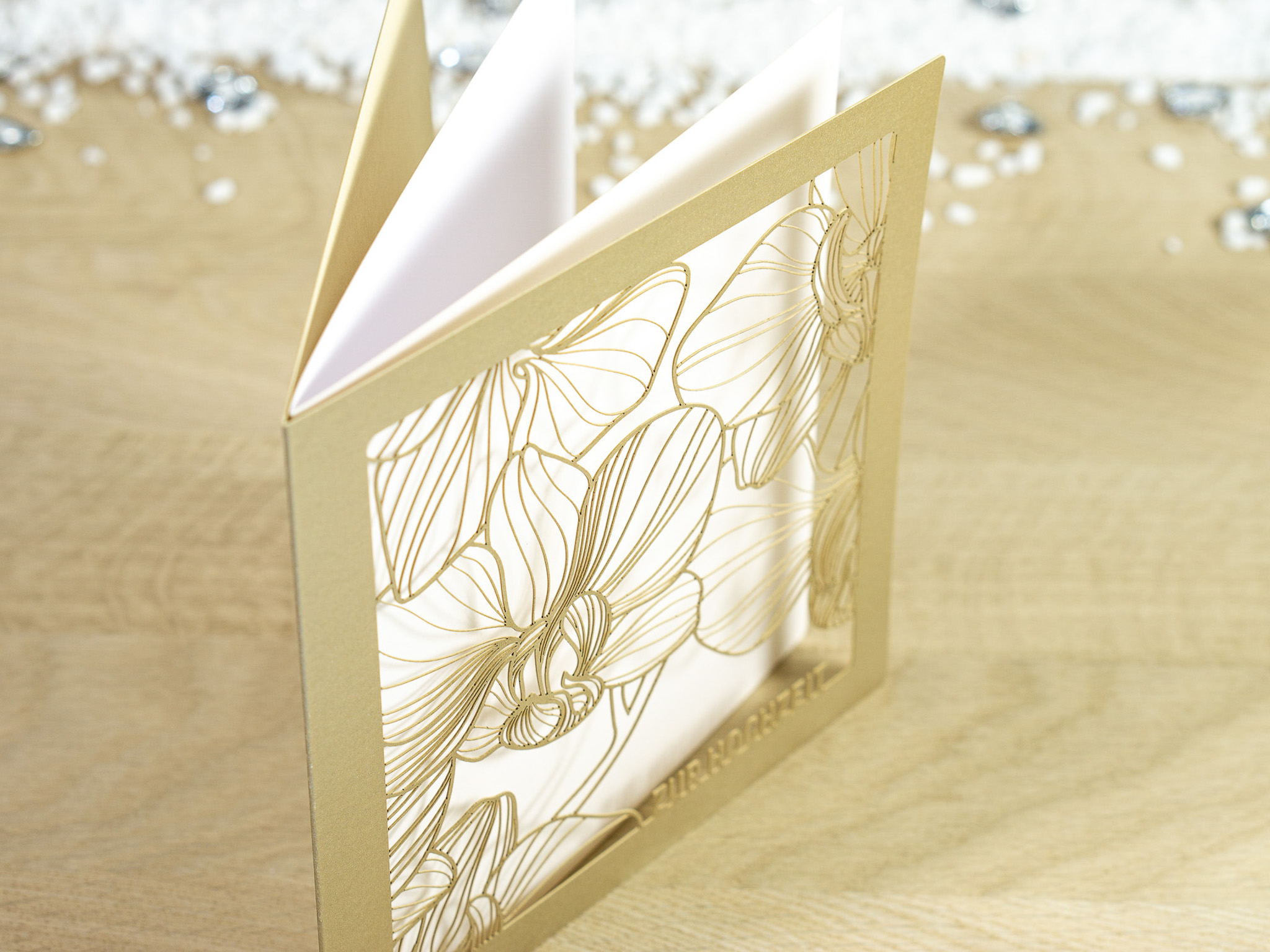 Zoom-In PALUXA Lasercut-Hochzeitskarte mit Orchideen Motiv, golden, stehend, seitlich.