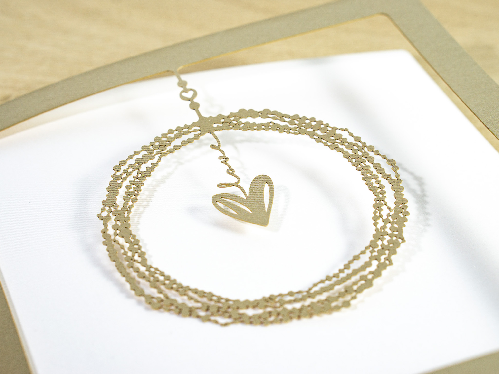 PALUXA_Liebe_im_Mittelpunkt_Perlgold_detail1.jpg Zoom-In PALUXA Lasercut-Hochzeitskarte mit Herz Motiv, golden, liegend.