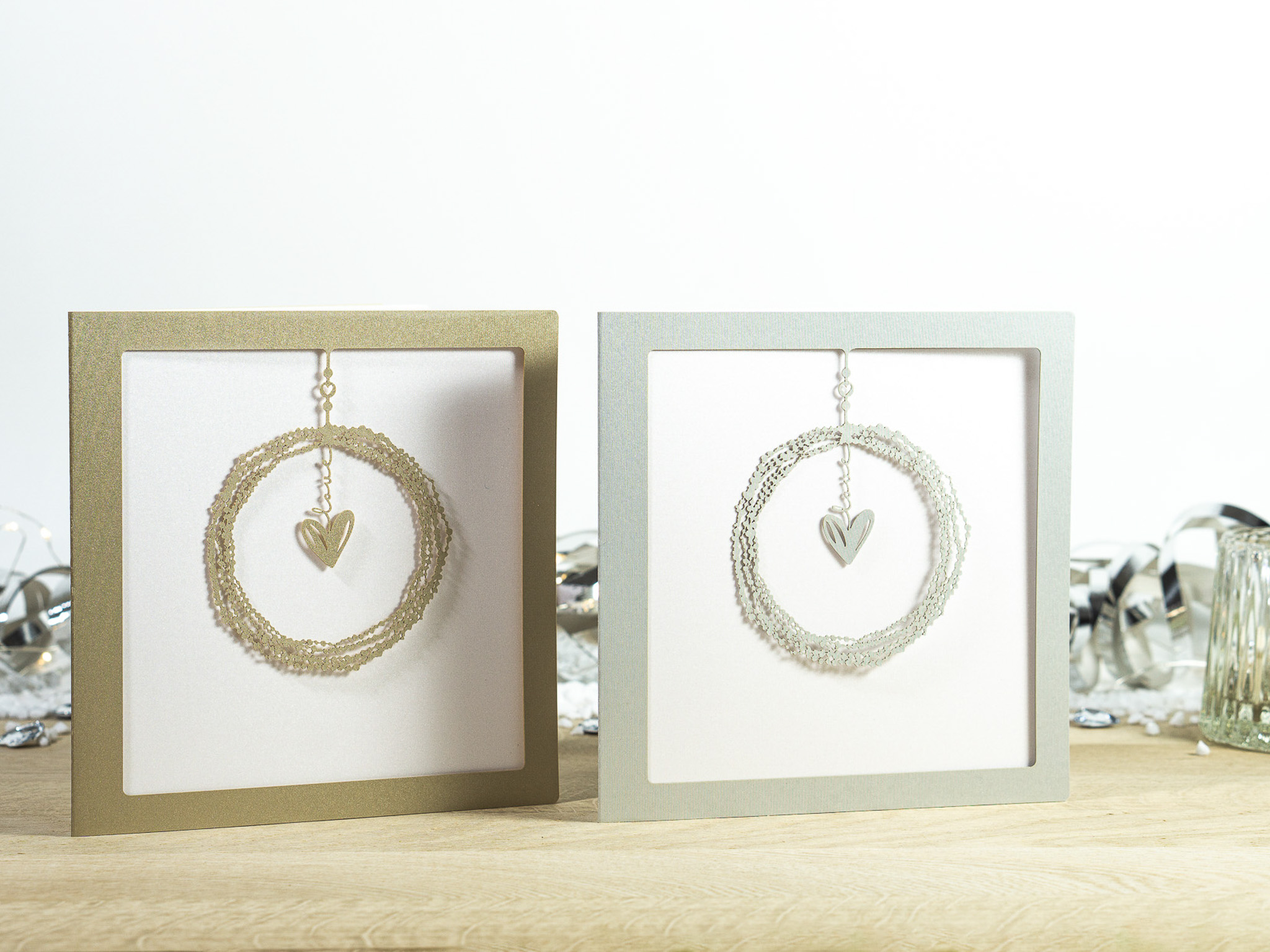 Zwei Farbvarianten PALUXA Lasercut-Hochzeitskarte mit Herz Motiv, golden und silber.