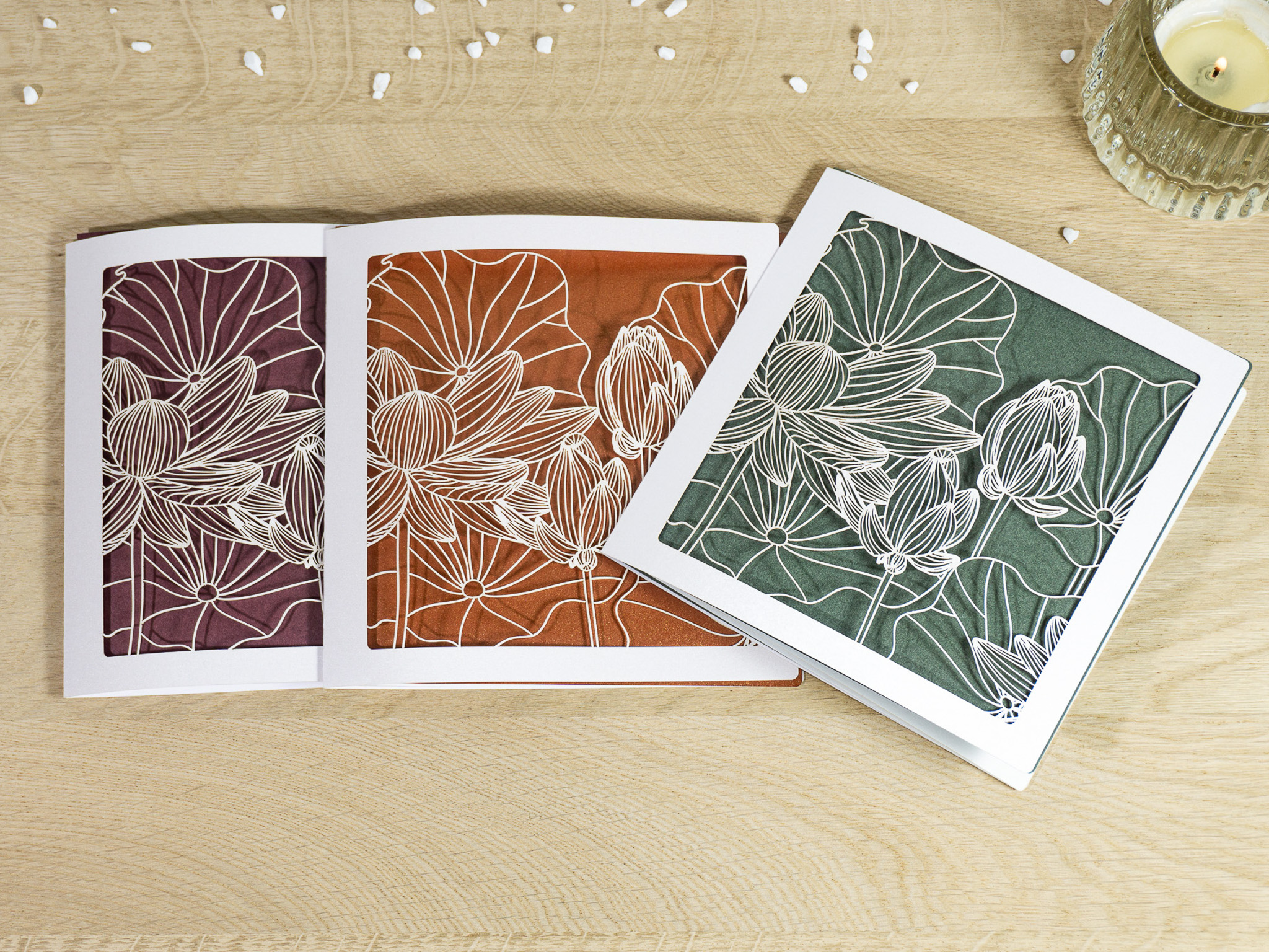 Drei Farbvarianten PALUXA Lasercut-Glückwunschkarte mit Lotusblüten Motiv, liegend.