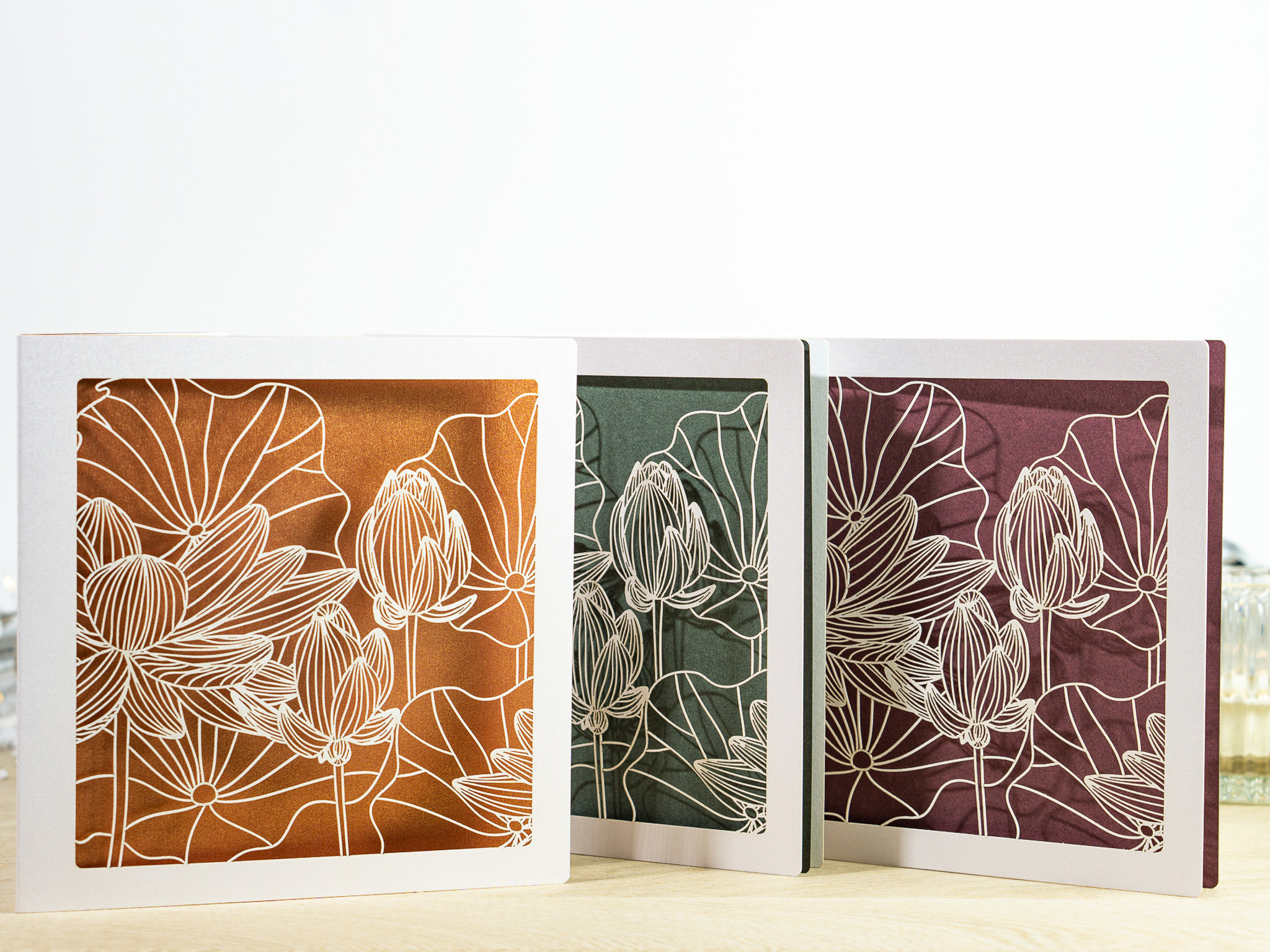 Drei Farbvarianten PALUXA Lasercut-Glückwunschkarte mit Lotusblüten Motiv, stehend.
