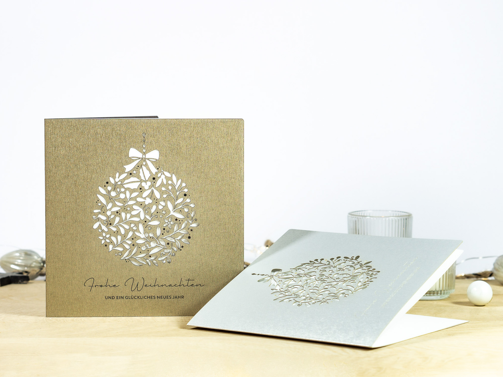 Zwei Farbvarianten PALUXA Lasercut-Weihnachtskarte mit Floraler Weihnachtskugel, in Farben Brownsilver und Silber.