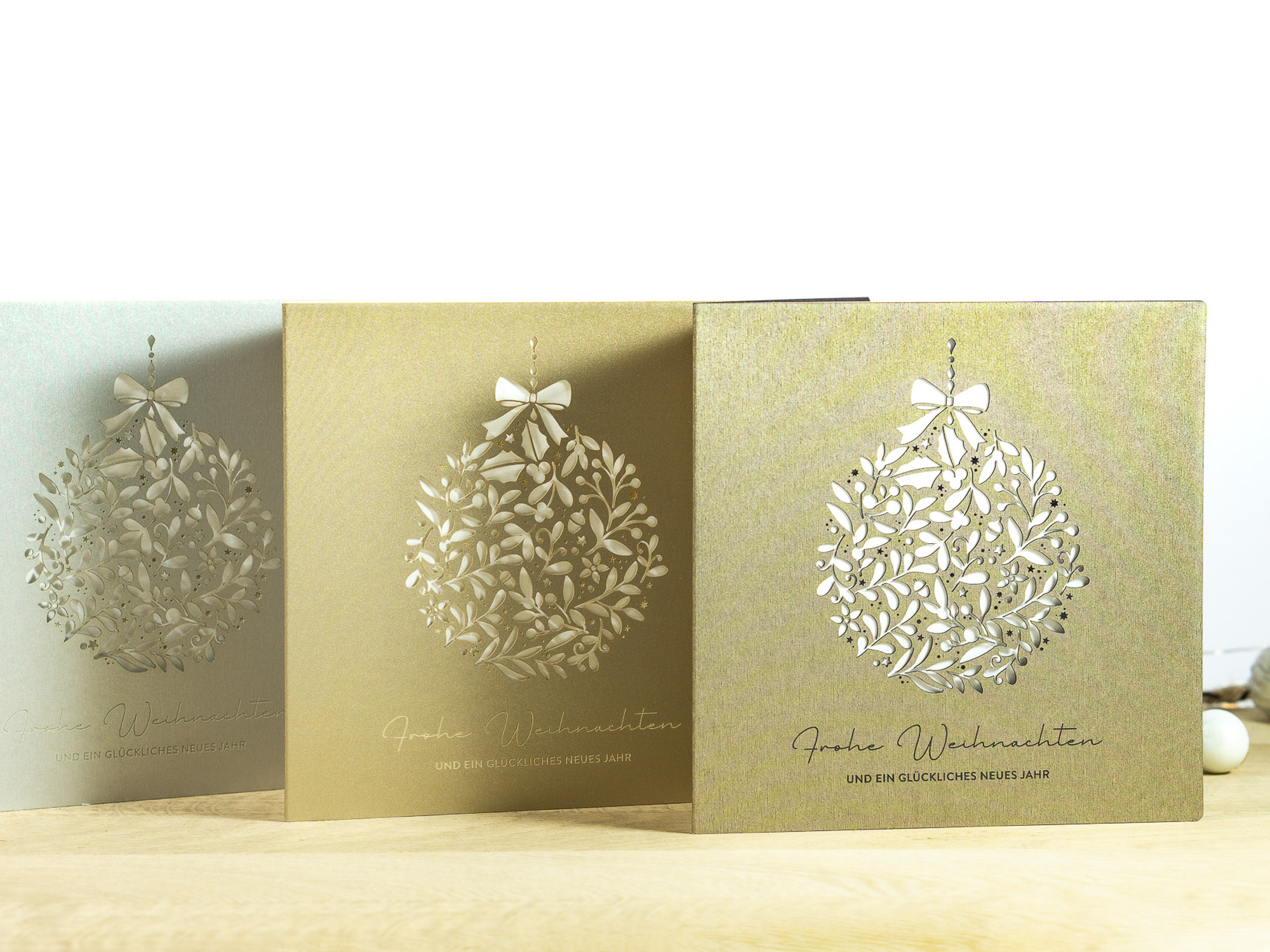Drei Farbvarianten PALUXA Lasercut-Weihnachtskarte mit Floraler Weihnachtskugel, stehend, in Farben Brownsilver, Gold, Silber.