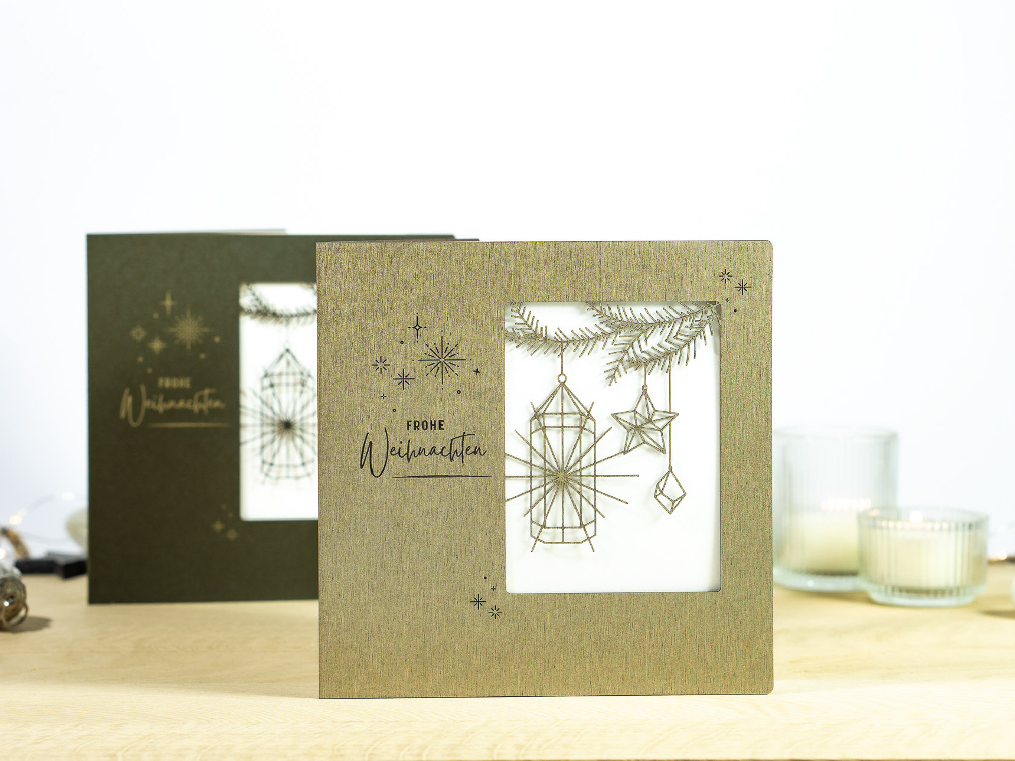 Zwei Farbvarianten PALUXA Lasercut-Weihnachtskarte mit Laternen Motiv, stehend, in Farben Brownsilver und Forestgreen.