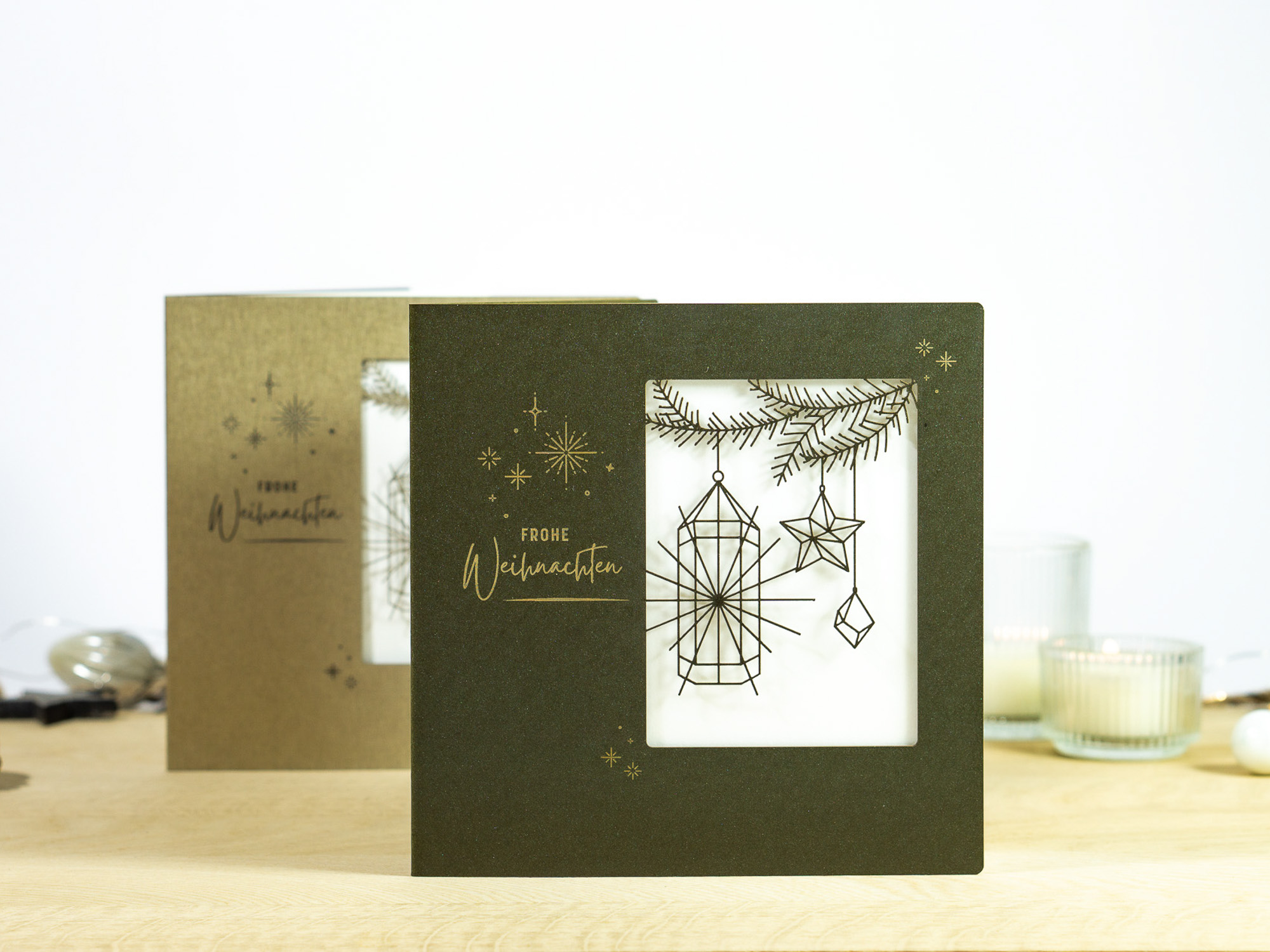 Zwei Farbvarianten PALUXA Lasercut-Weihnachtskarte mit Laternen Motiv, stehend, in Farben Forestgreen und Brownsilver.