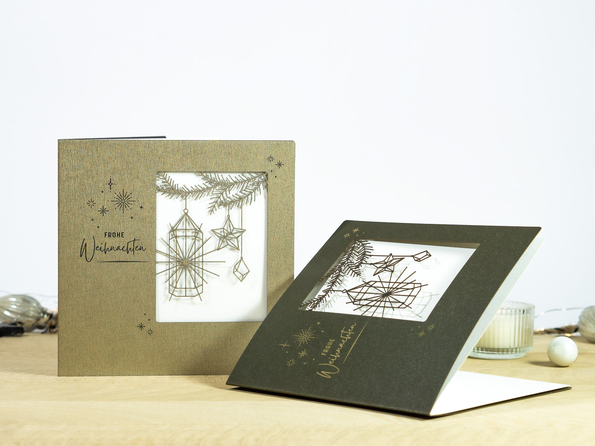 Zwei Farbvarianten PALUXA Lasercut-Weihnachtskarte mit Laternen Motiv, in Farben Forestgreen und Brownsilver.